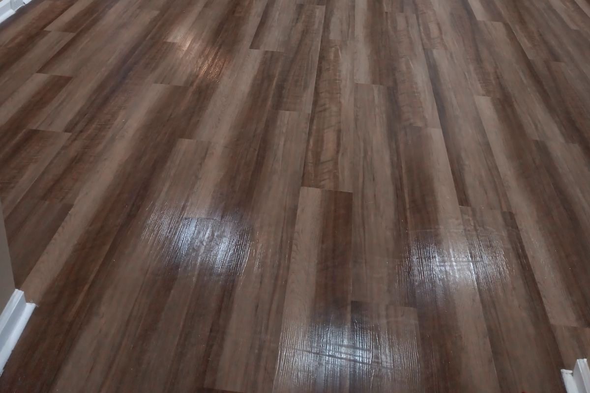 Dark luxury vinyl plank in a hallway with white trim