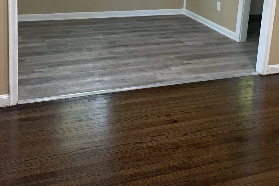 Wide plank flooring in a dining room with a modern light fixture